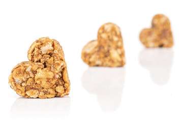 Group of three whole healthy brown cereal heart with cocoa placed diagonally isolated on white background