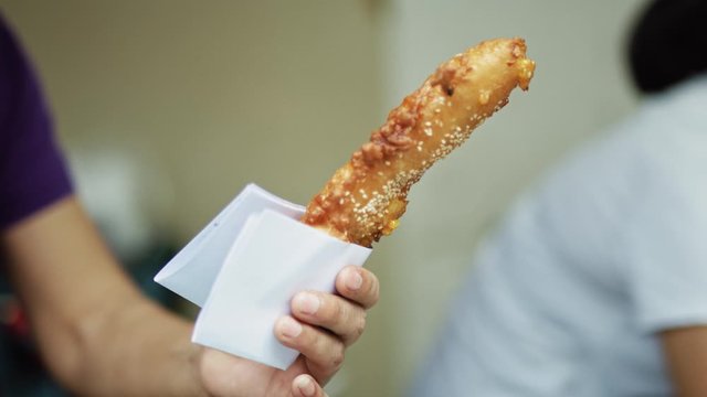Handheld view of tourist buying Vietnamese street food. Shot with RED helium camera in 8K