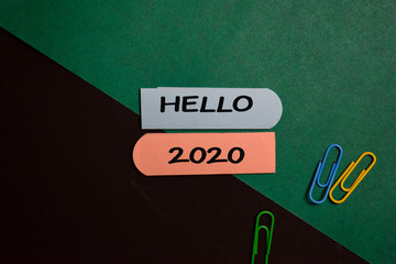 Hello 2020 write on a sticky note isolated on Office Desk