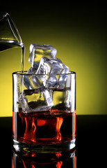 Whisky Glass with ice cubes and Drink poured in
