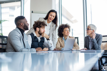A crew of professionals having a meeting in the boardroom.
