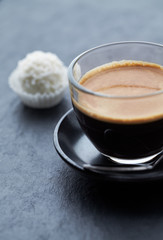 Coffee in glass cup on dark stone background. Close up. 