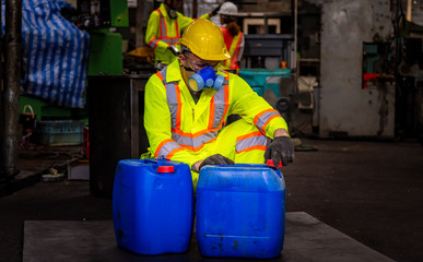 A Engineer industry wearing safety uniform ,black gloves and gas mask under checking chemical tank in industry factory work.