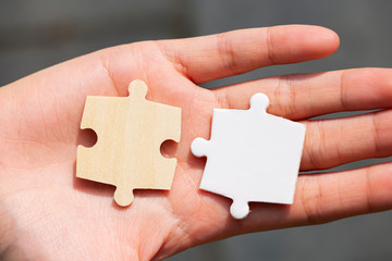 Two puzzle pieces in the palm of a hand.
