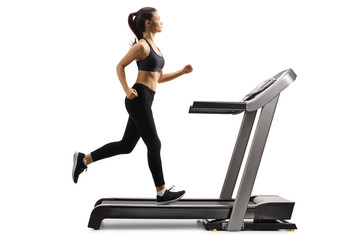 Young female in black leggings running on a treadmill