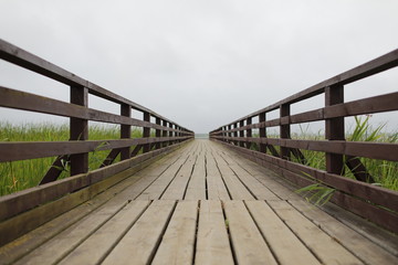 Obraz premium background with wooden bridge with fence and cloudy sky