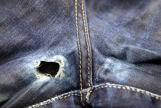 hole and scuffs on jeans between the legs