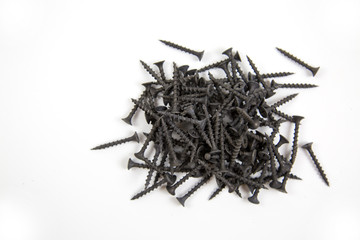 Wood screws are black arranged in a row isolated on a white background, the idea is the concept of free space for text.  Construction, repair, fasteners.