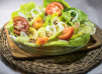 preparation of a side dish of natural and healthy food such as lettuce with tomatoes onions and more healthy food