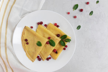 Pancakes with berries on a white plate, Shrovetide