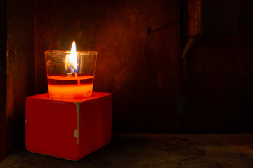 A bright candle light in the room with stained wall