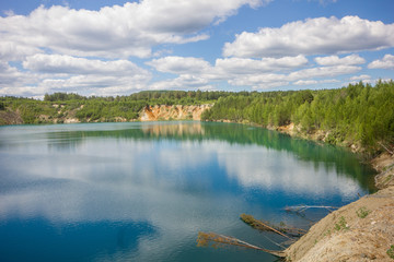 Flooded emerald quarry lake with blue water landscape