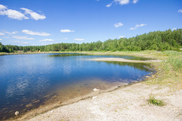 Fototapeta na wymiar Flooded emerald quarry lake with blue water landscape