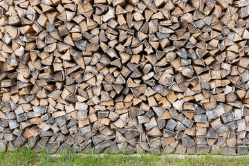 Wooden logs wall storage on green grass