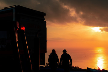 silhouette of man and woman at sunset planning the day at work