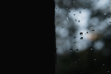 Rain drops on a window. Dark moody autumn concept