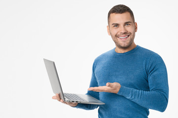 Young man holding laptop and showing computer isolated on white background