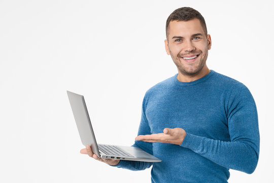 Young man holding laptop and showing computer isolated on white background