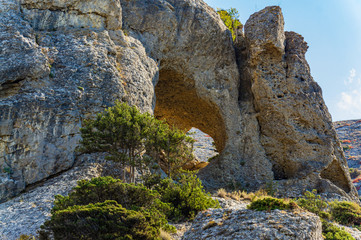 Cape Alchak on southern coast of Crimea on  outskirts of resort town of Sudak. Fabulous view of big mountain with Aeolian harp grotto on Alchak-Kaya trail. Close-up of huge stones and natural boulders