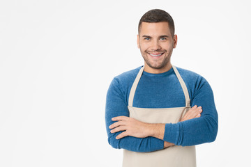Young handsome shopkeeper man wearing apron standing over isolated white background - obrazy, fototapety, plakaty