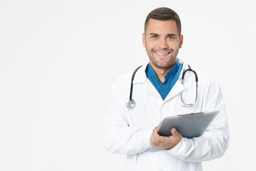 Young doctor smiling with stethoscope and holding clipboard on white color background