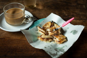 fried Roti sprinkle with sweetened condensed milk and cup of coffee for breakfast
