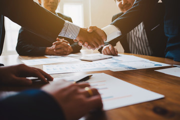 Young man business people shaking hands after brief job for contract signing in modern office with...