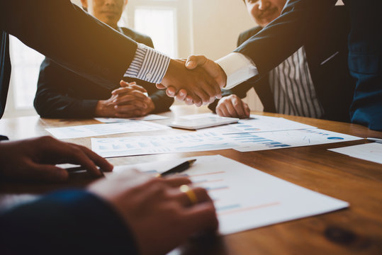 Young Man Business People Shaking Hands After Brief Job For Contract Signing In Modern Office With Vintage Picture Style, Colleagues At Meeting Teamwork Of Partnership.