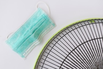 Put on mask before clean the dirty grill of electric fan, air pollution and health care concept.