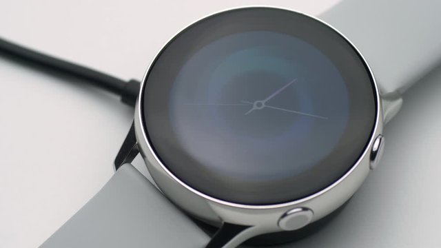 smart watch charging on wireless charging stand pad on white background