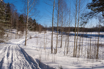 Landscape with a small river on a winter sunny day and blue sky, 02/08/2020, Ivanovo, Russia.