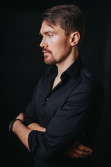 Handsome man. Photo in a photo studio on a black background. A young man expresses his emotions...