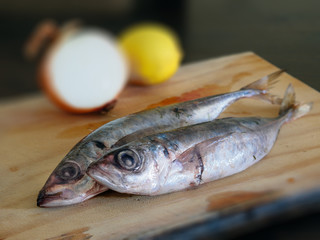 Two raw mackerels on a wooden board