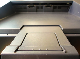 paper tray on the printer. black printer. printer part close-up