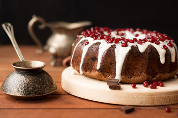 chocolate cake with pomegranate on a wooden table, a cozy breakfast, English tea party, chocolate dessert, delicious Gugelhupf with pomegranate, photo of sweet dishes with free space for text