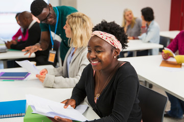 Smiling confident young female community college student in classroom