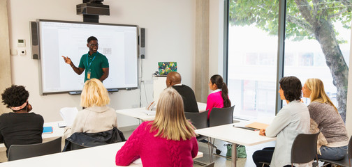 Community college students watching instructor leading lesson