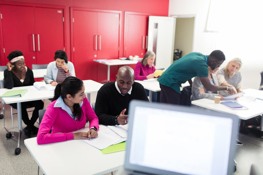 Community college students working together studying in classroom
