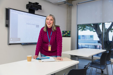 Portrait smiling community college instructor preparing in classroom