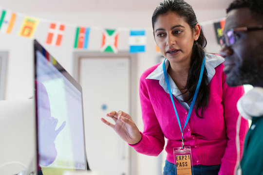 Community college instructor helping student at computer