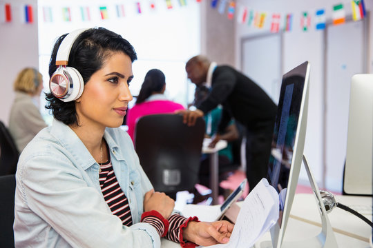 Focused female community college student headphones using computer