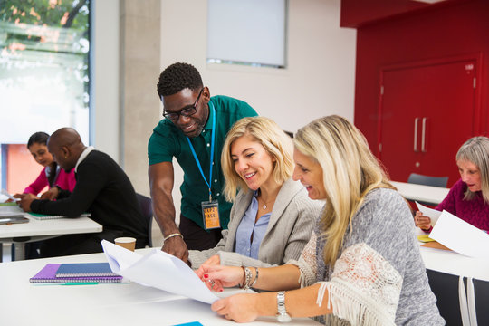 Community college instructor and students talking in classroom