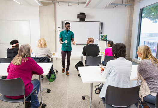 Community college students watching instructor leading lesson