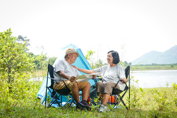 The elderly couple camping in the forest, happy to relax in retirement. Senior community concepts
