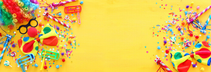 carnival, party and Purim celebration concept (jewish carnival holiday) over yellow background