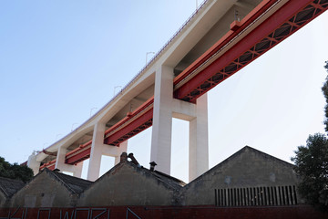 Lisbon bridge Ponte 25 de Abril over spans houses and districts.