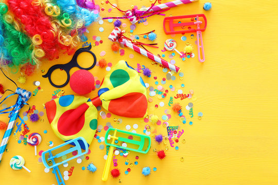 carnival, party and Purim celebration concept (jewish carnival holiday) over yellow background