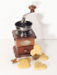 Coffee grinder and cookies for Valentine's Day on white background.