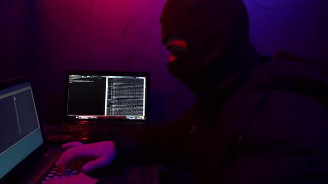 Cracker in a mask will break the computer. Theft of digital data. On the background of reading all the data