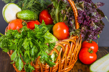 Fresh vegetables in basket on wooden background